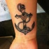 Tatuaje en la muñeca, ancla negra con corazón