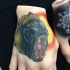 Tatuaje en la mano,  babuino enfadado y sol brillante