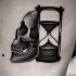 Teschio nero dotwork con tatuaggio a clessidra sul lato