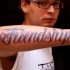 citazione amicizia lettere blu tatuaggio su braccio