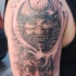 Tatuaje de samurái y máscara en el brazo