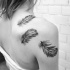 realistiche piume nero e bianco tatuaggio su spalla
