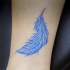 carina piuma blu tatuaggio su gamba