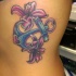 Tatuaje en las costillas,
ancla azul oscuro con lirios rosas encantados