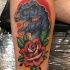 Dinosaur head and red rose tattoo on leg