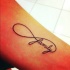 Tatuaje en el antebrazo, palabra familia con símbolo de infinito