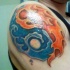 Tatuaggio colorato sul deltoide l'aqua & il fuoco in stile Yin-Yang