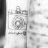 segui citazione tuo cuore con camera fotografica tatuaggio su polso