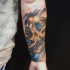 Tatuagem de caveira dourada no antebraço