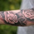 Tatuaje en el antebrazo, rosas con el fondo oscuro