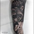 Gran tatuaje de mapache negro y gris en el brazo