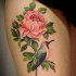Tatuaje en el muslo, 
peonía de color rosa suave y pájaro bonito