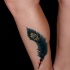 Tatuaje en la pierna, pluma de pavo real color turquesa
