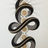 Long black snake and brown circles tattoo design