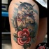Tatuaggio con gufo e rosa sulla coscia