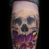 Purple flower and skull tattoo on leg