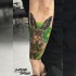 Coelho realista em grama tatuagem no antebraço