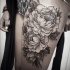 Tatuaje en el muslo,  flores enormes descoloridos