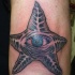 carino inchiostro nero stella marina con occhio blu tatuaggio su braccio