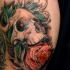 Skull with pink rose in mouth tattoo