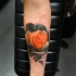 Very realistic rose tattoo on forearm