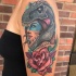 Woman in dinosaur hemlet tattoo on shoulder