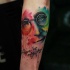 Abstract style colored arm tattoo on Lennon face with lettering