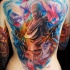 Abstract style colored back tattoo of mystical looking figure with feather
