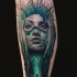 Abstract style colored leg tattoo of woman face with forest