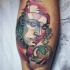 Abstract style colored mask with lighthouse and orb tattoo on leg