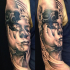 Abstract style colored shoulder tattoo of corrupted woman face combined with human skull