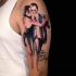 Abstract style colored shoulder tattoo of dancing couple with lettering