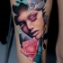 Abstract style colored thigh tattoo fo woman face with flowers