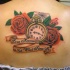 Tatuaje en la espalda, reloj con rosas, telaraña y inscripción