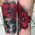 Tatuaje  de amapolas delicadas con cráneo viejo