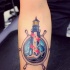 Tatuaje en el antebrazo, faro magnífico con timón