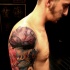Accurate painted colored lotus flower tattoo on shoulder combined with flying bird