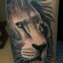 Tatuaggio colorato e preciso della testa di leone con grandi occhi gialli
