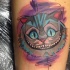 Tatuaje en el muslo,  gato de cheshire encantador  multicolor