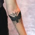 Tatuaje en el antebrazo,
polilla negra oscura