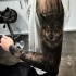 Tatuaje en el brazo, lobo en el bosque oscuro