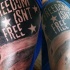 Tatuaje en el brazo, bandera americana militar con cita