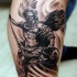 Tatuaje en el brazo,
ángel guerrero con lanza y cadena