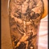 Tatuaje en el brazo, ángel con espada en el cielo, demonio