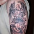 Tatuaje en el brazo,
ángel que lucha con demonio