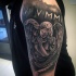 Antic style black ink shoulder tattoo of angel statue with emblem