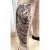 Tatouage de jambe à l'encre noire de style Art de tête de lion avec divers ornements