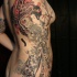 stile asiatico dettagliato multicolore geisha con grandi fiori tatuaggio su lato