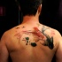 Asian traditional multicolored upper back tattoo of swimming carp fishes