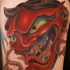 Asian traditional shoulder tattoo of red colored demonic mask